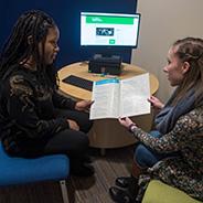 Two students looking at wellness materials