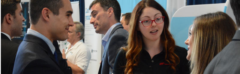 Two students talk with a recruiter at a career fair on campus.