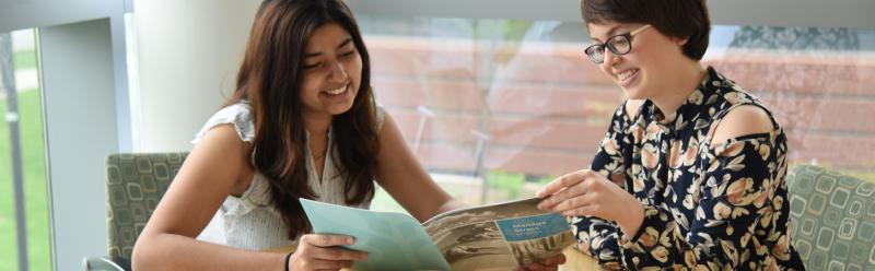 Two women reading a Health brochure