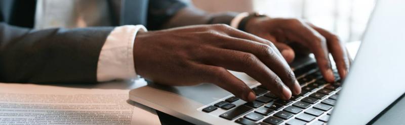 Hands of a man working on a laptop