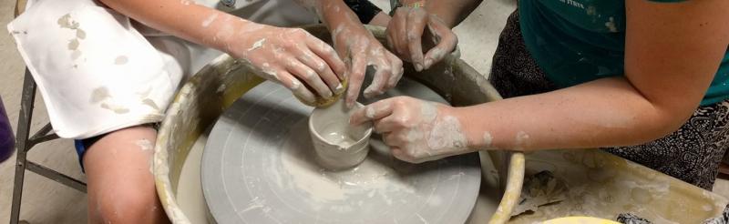 Instructor showing how to use a pottery wheel