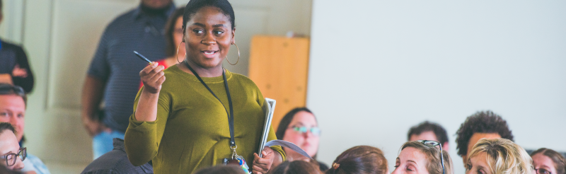 A residence life team member address the group during a staff meeting
