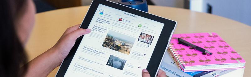 Person holding tablet reading New York Times