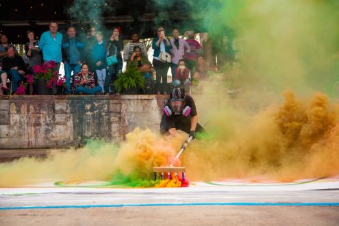An artist painting with colorful smoke