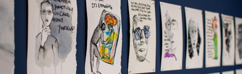 Several drawings hung by magnets that focus on the topic of anxiety and depression