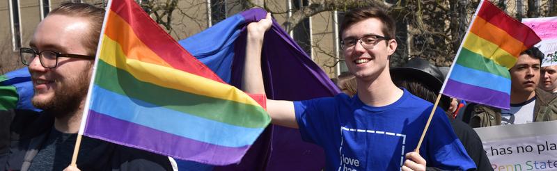 students waving rainbow flags